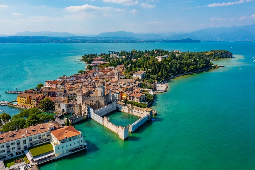 Aerial view of a medieval lakeside castle on Lago di Garda.