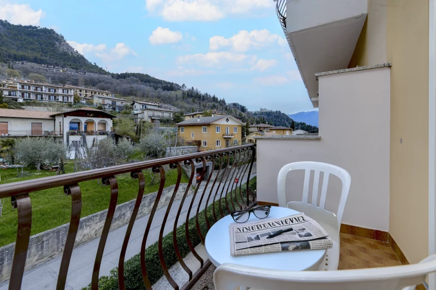 Balcone con tavolino, giornale e vista sul borgo collinare vicino al Lago di Garda