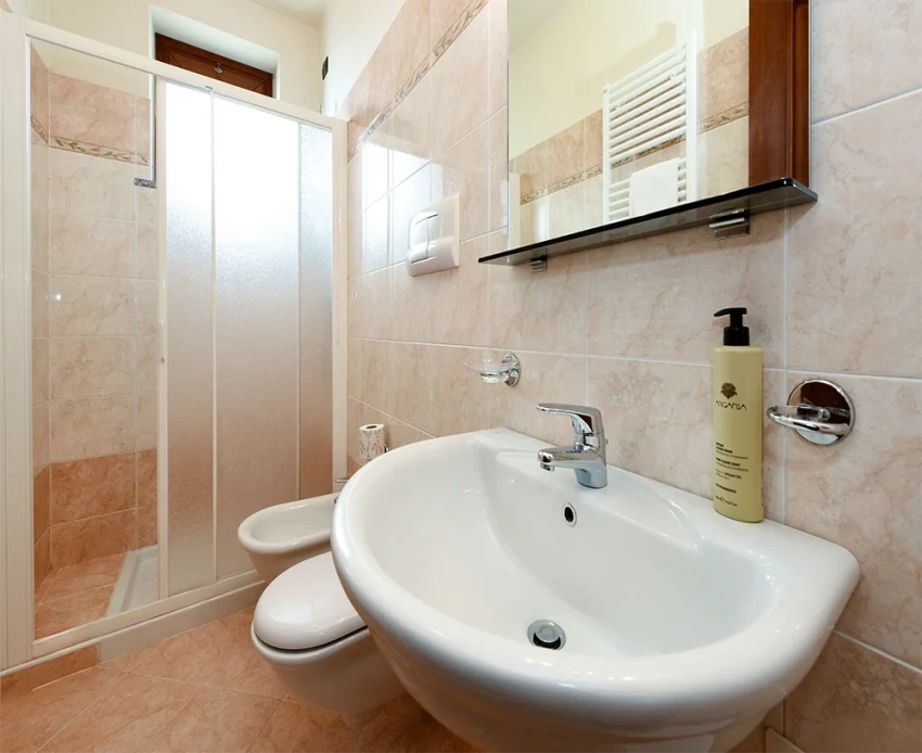 Bright tiled bathroom with sink, toilet, bidet and shower near Lago di Garda