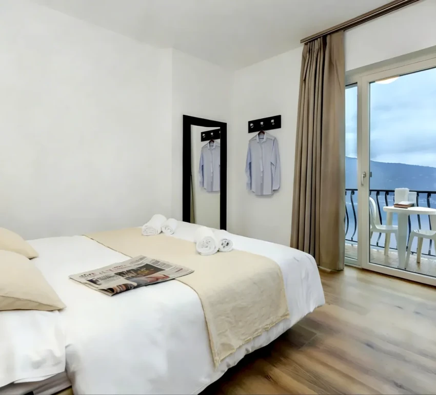 Camera luminosa con balcone vista Lago di Garda, letto e tavolino esterno