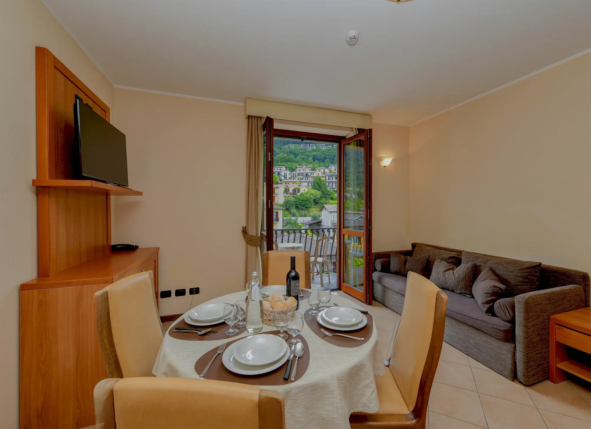 Soggiorno con tavolo apparecchiato e balcone sul Lago di Garda