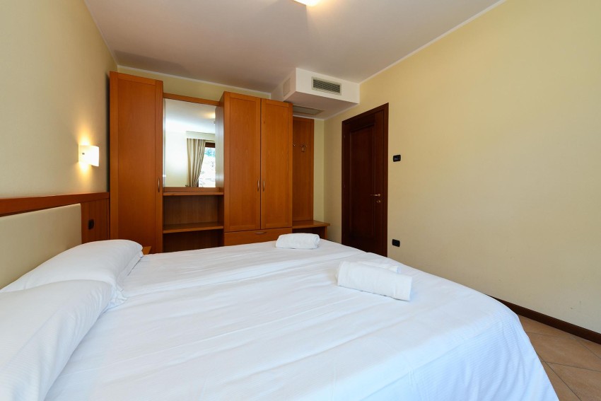 Gemütliches Doppelzimmer mit Kleiderschrank und Spiegel nahe dem Lago di Garda