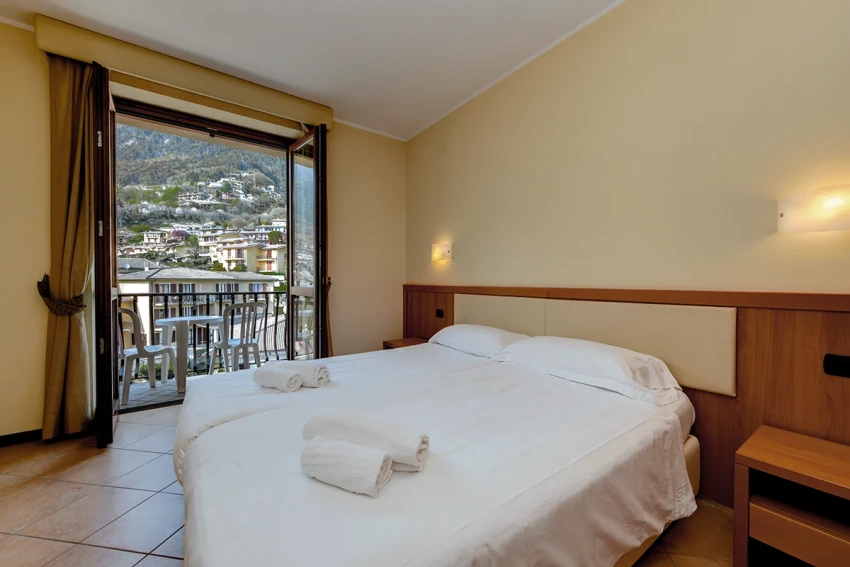 Bright hotel room with double bed and balcony, Lago di Garda