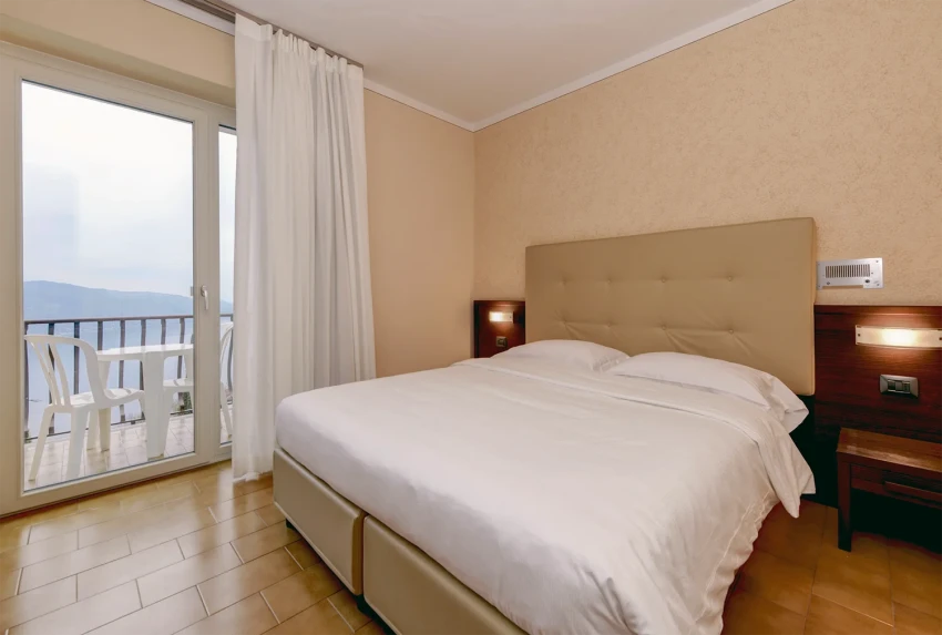 Hotel room with double bed and balcony overlooking Lake Garda