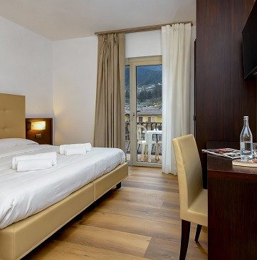 Modern hotel room with balcony overlooking Lake Garda and mountains