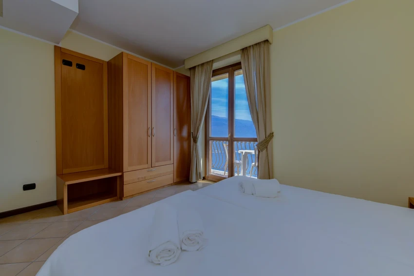 Helles Schlafzimmer mit Balkon und Blick auf den Gardasee