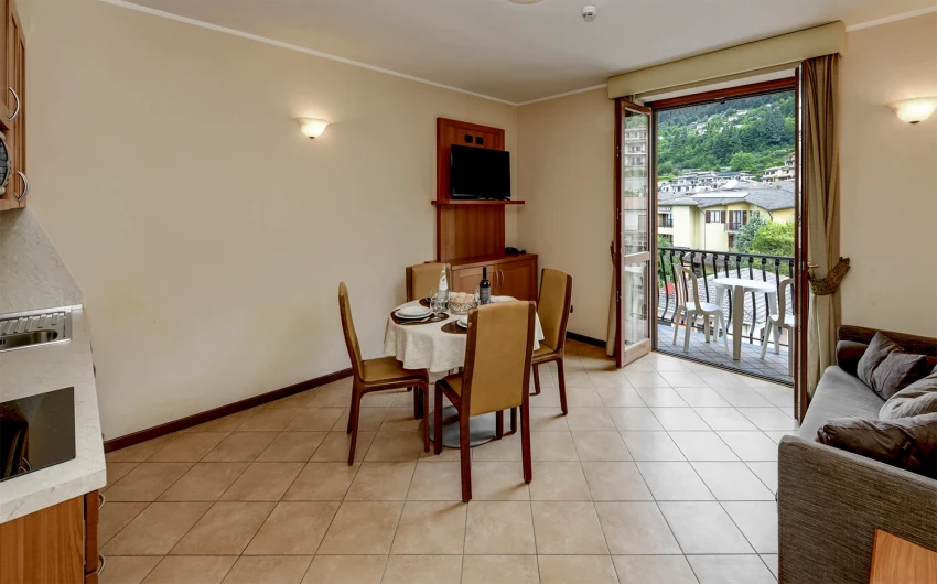 Soggiorno con tavolo apparecchiato e balcone vista Lago di Garda